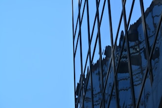 Close-up of aluminum and glass facade with reflections of the sky.