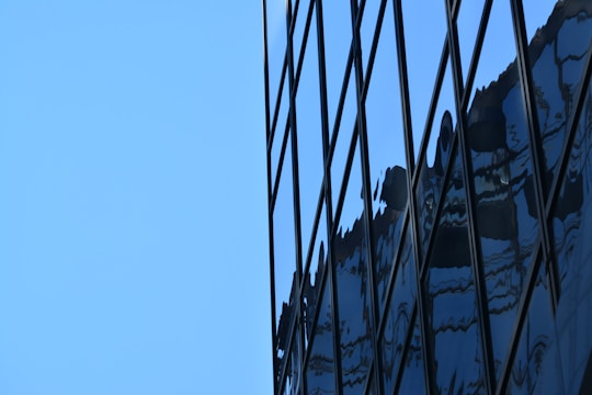 Close-up of aluminum and glass facade with reflections of the sky.