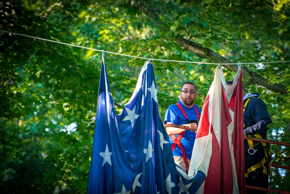 hombre de pie cerca de un textil rojo y azul que cuelga