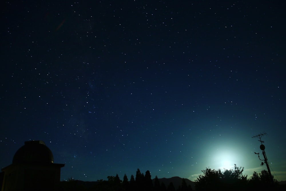 El cielo nocturno con estrellas y la luna en la distancia