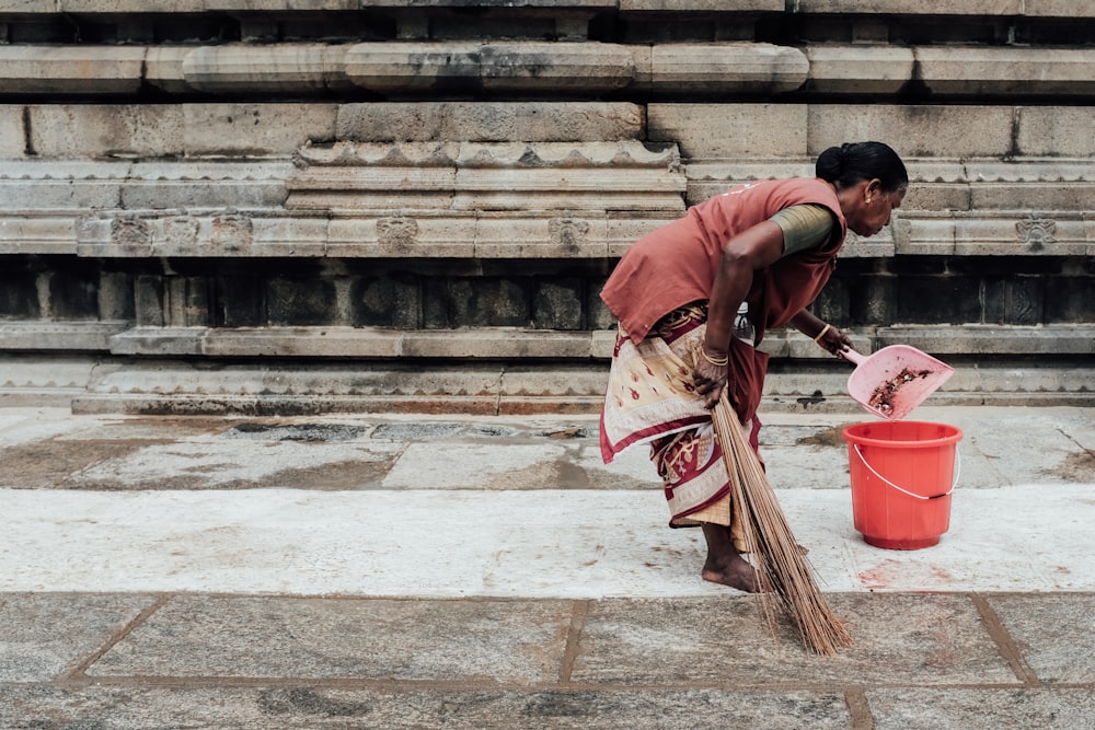 woman holding red dustpan