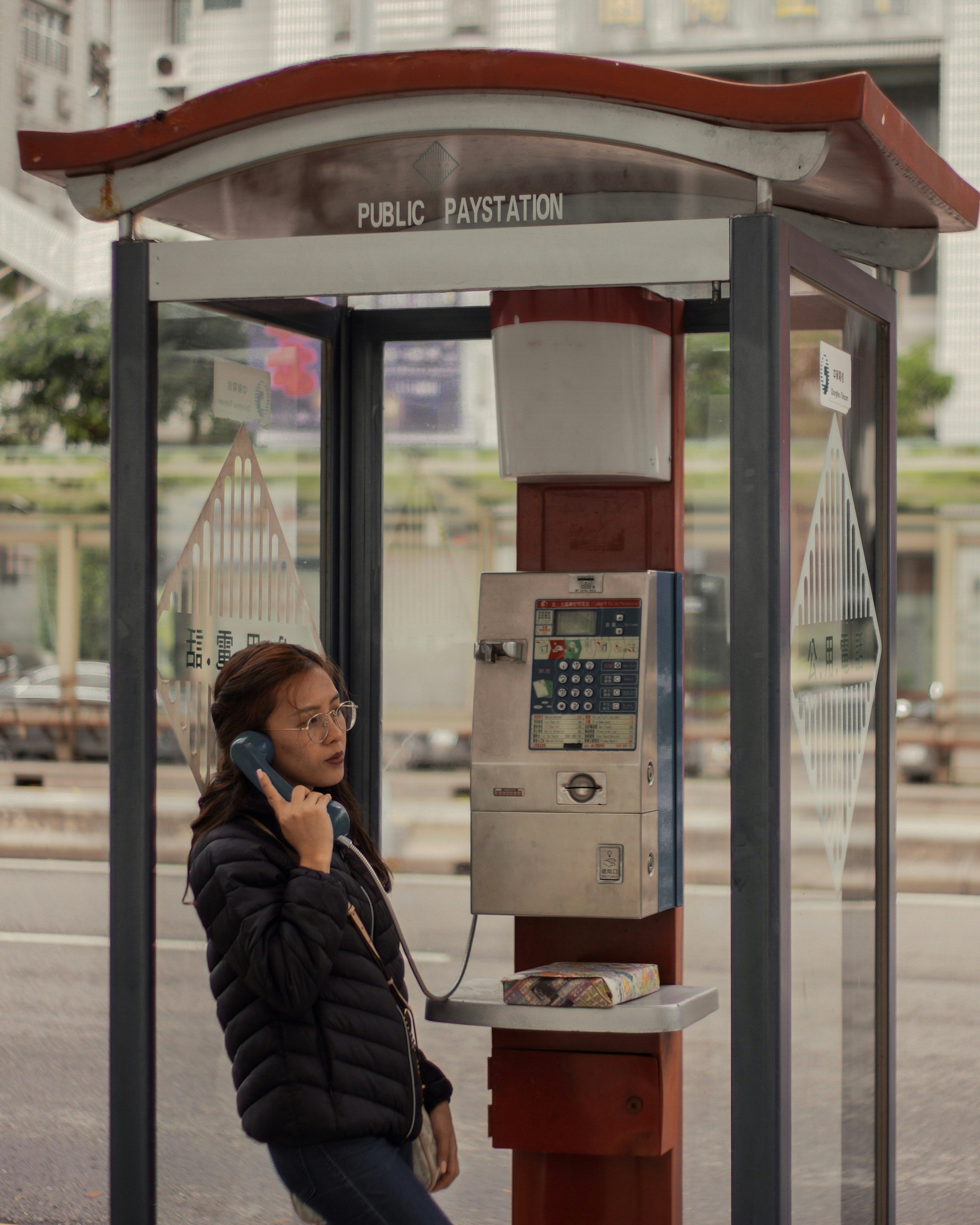 woman calling using the telephone booth