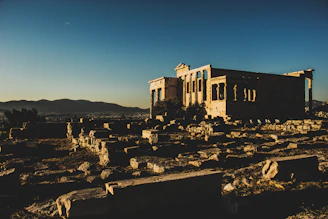 Ruins of an ancient stone city bathed in golden sunset light.