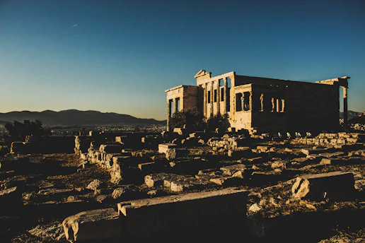Ancient Greek ruins bathed in golden sunset light, evoking timeless history.