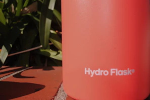 Elegant shot of an Eco Flask being held in natural daylight with a blurred Scandinavian-inspired interior background.