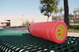 A smiling family using reusable water bottles and lunch containers outdoors on a sunny day.