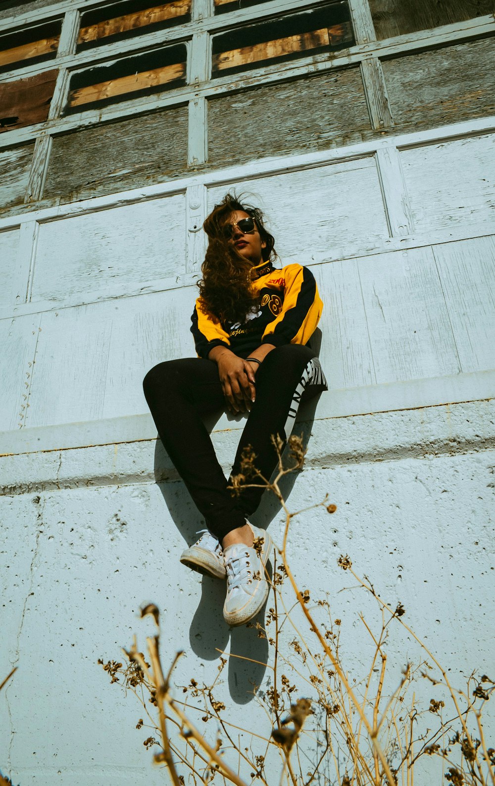 woman wearing black and yellow track suit while sitting