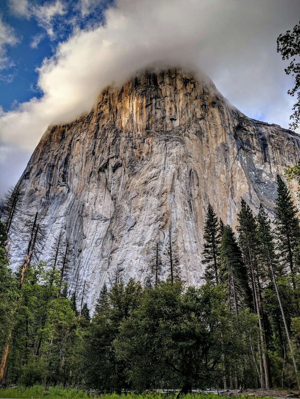 white clouds above rock mountain