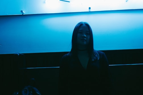 A sleek minimalistic photo of a lone figure illuminated by yellow neon against a dark backdrop.