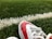 A close-up of a pair of vibrant football cleats on a grassy field.
