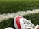 A close-up of a pair of vibrant football cleats on a grassy field.