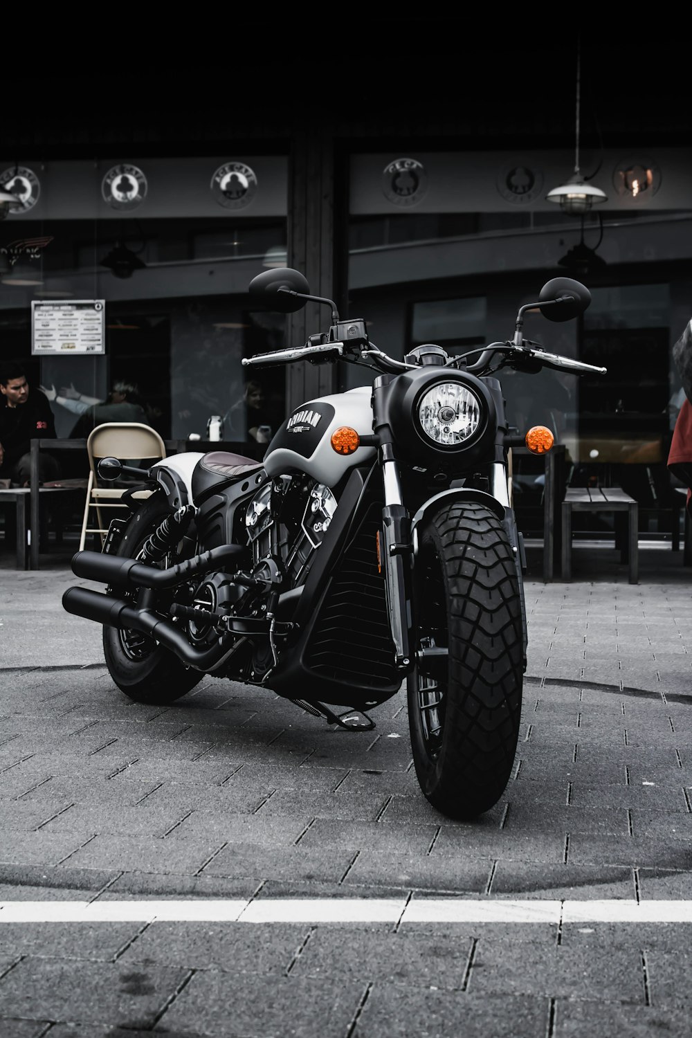 Schwarz-graues Cruiser-Motorrad neben schwarzem Betongebäude geparkt