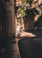 Tourists walking through the ancient streets of Fez medina under sunlight.
