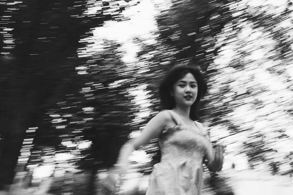 Photographie en niveaux de gris d’une femme entourée d’arbres