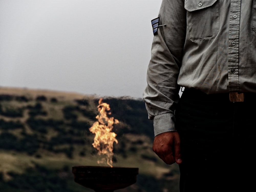 man standing beside firepit