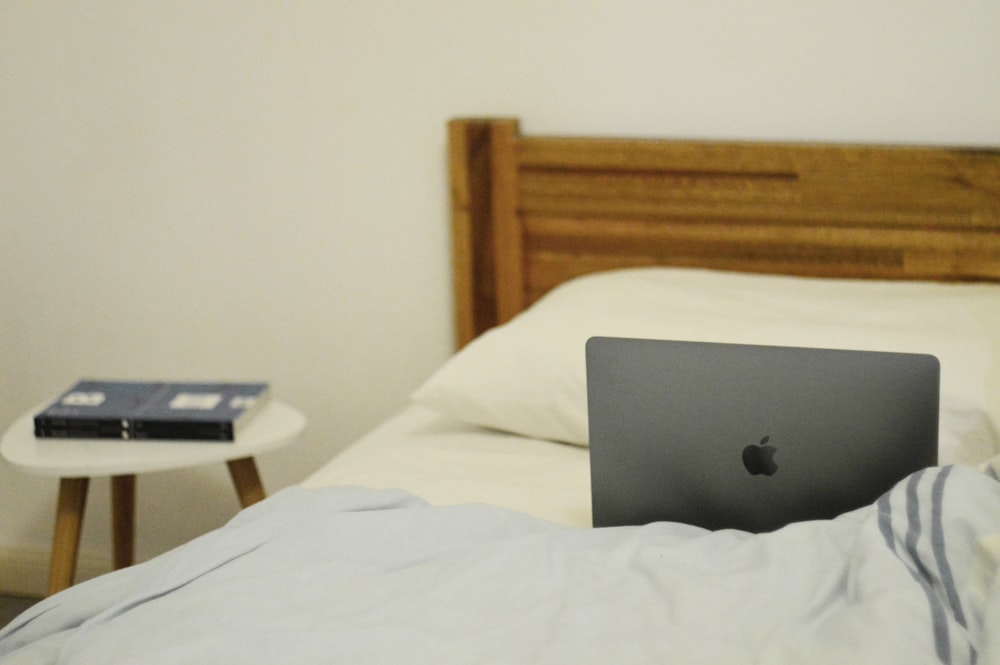 部屋のベッドの上のシルバーのMacBook