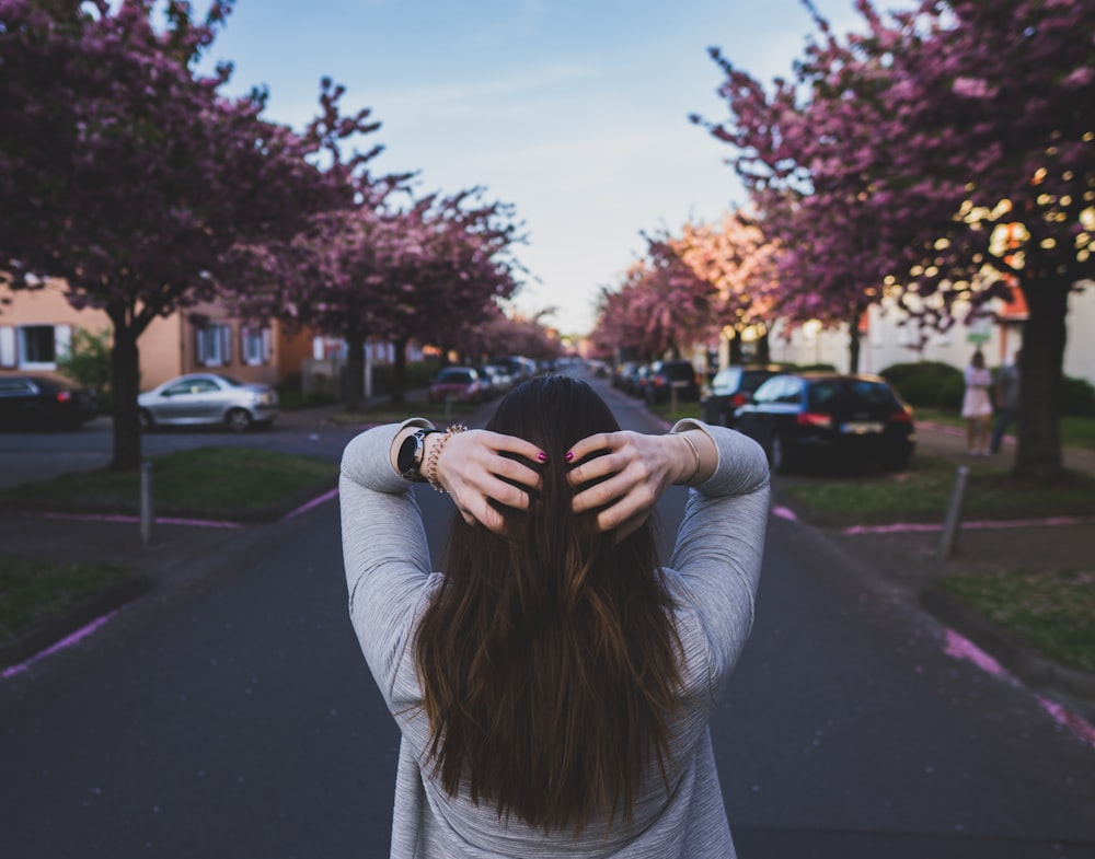 woman standing in the middle of the road during daytime