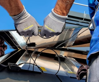 two men carrying a metal sheet