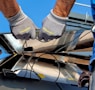 two men carrying a metal sheet