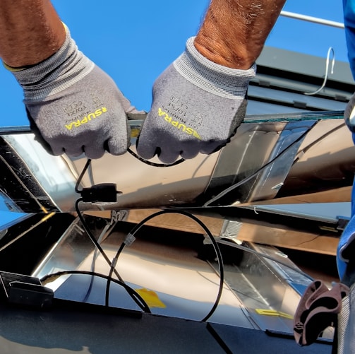 two men carrying a metal sheet