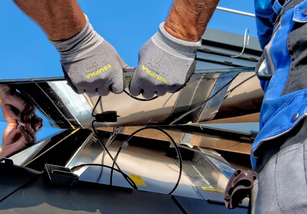 two men carrying a metal sheet