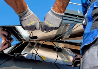 two men carrying a metal sheet