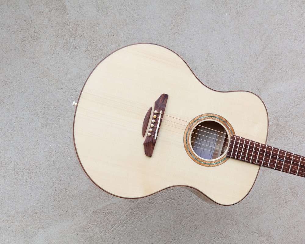 white and brown wooden dreadnought guitar