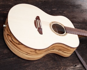 white and brown acoustic guitar