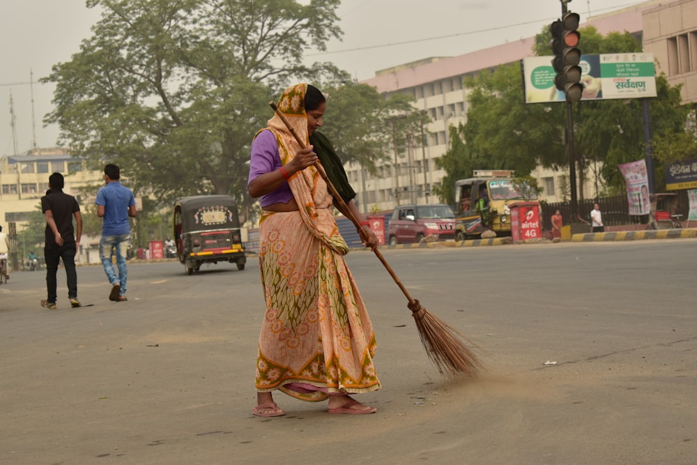 woman holding broom stick during daytime