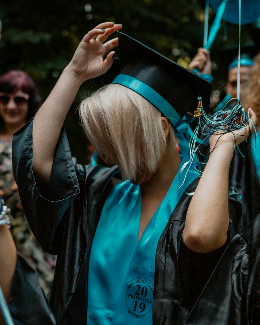 woman wearing blue and black graduation coat