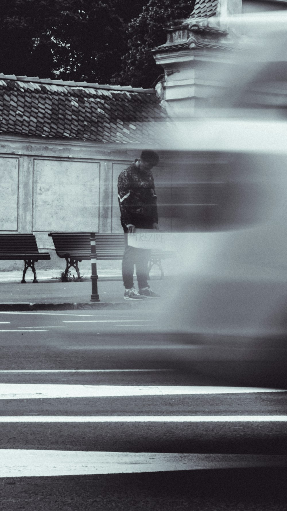 ein verschwommenes Foto einer Person, die neben einer Bank steht