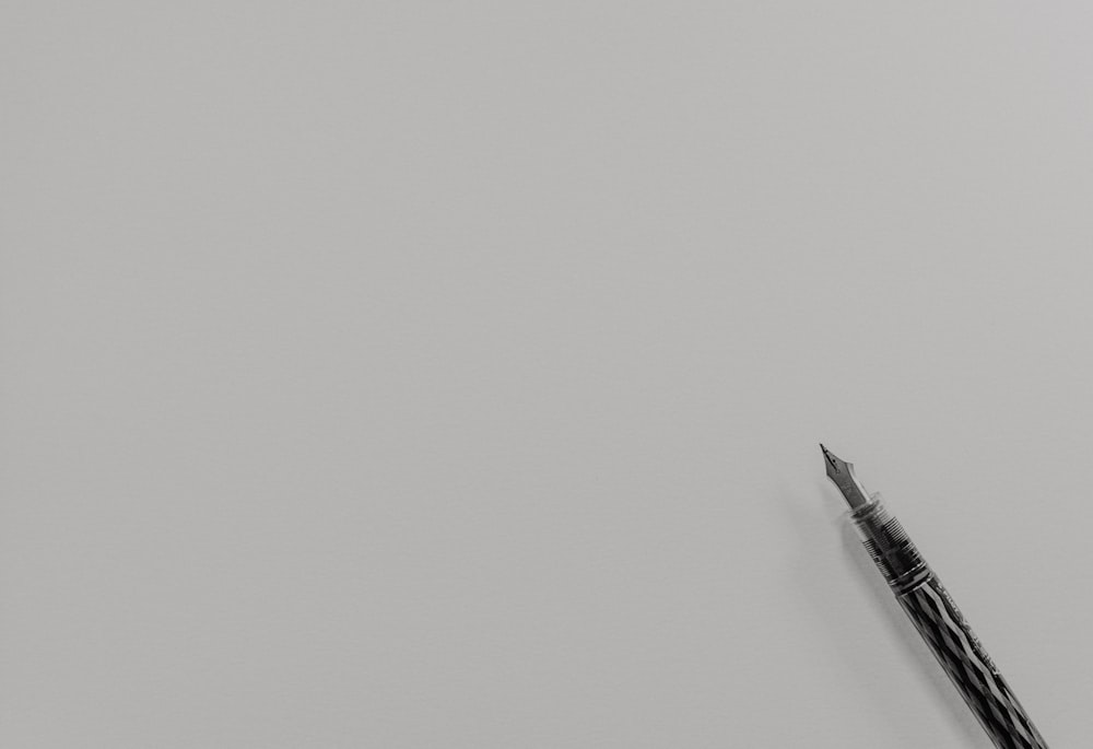 foto in scala di grigi della penna stilografica