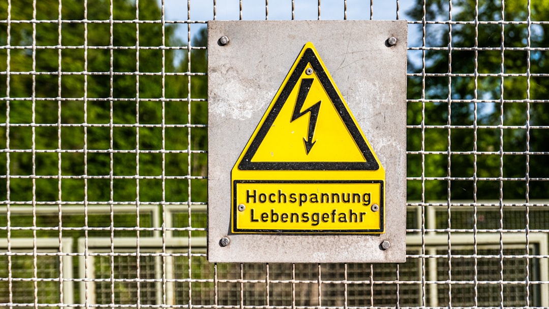 High voltage sign near a railway track.
