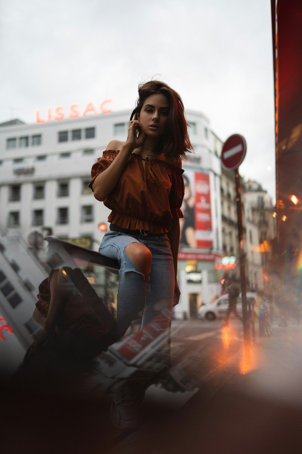 woman in red off shoulder blouse and blue distressed denim jeans