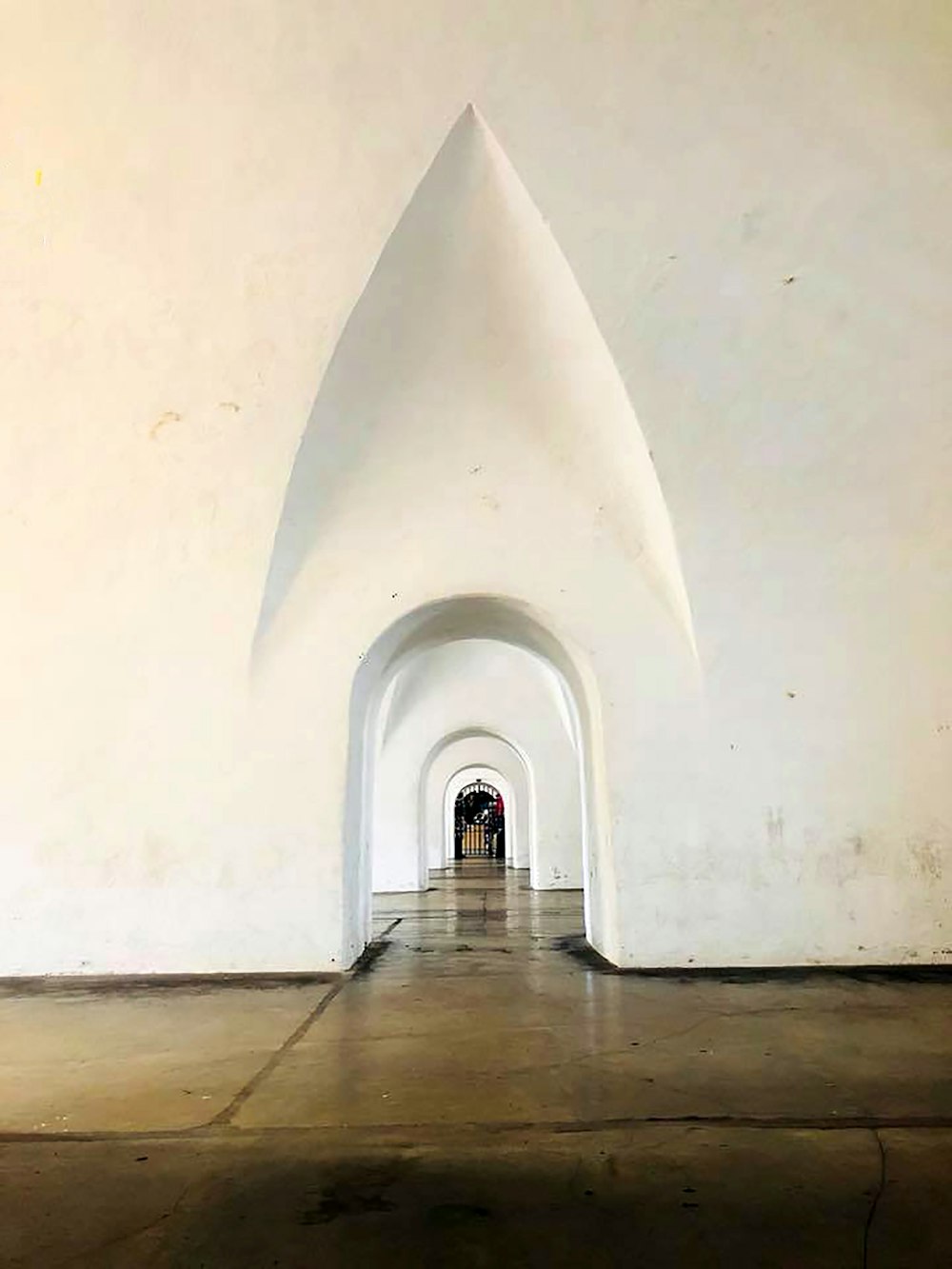 a long white tunnel with a person walking through it