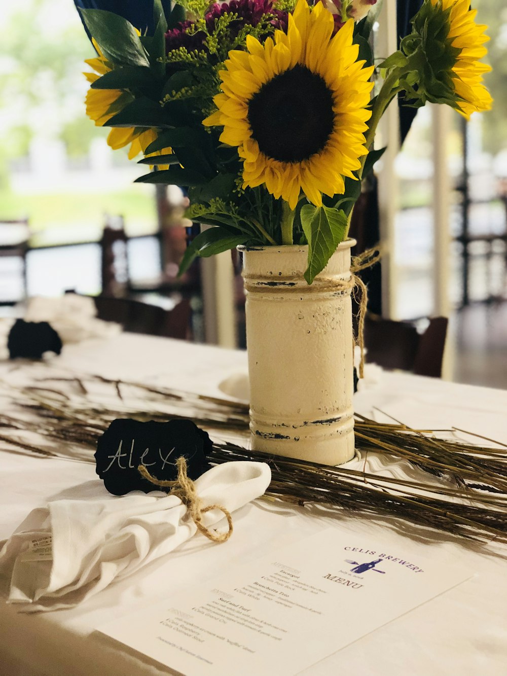 yellow sunflower in vase on top of table