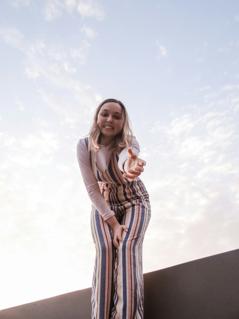 woman in multicolored striped jumpsuit and white sweater