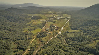 Aerial view of fertile agricultural land bordered by rugged hills and winding rivers.