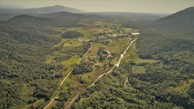 Aerial view of fertile agricultural land bordered by rugged hills and winding rivers.
