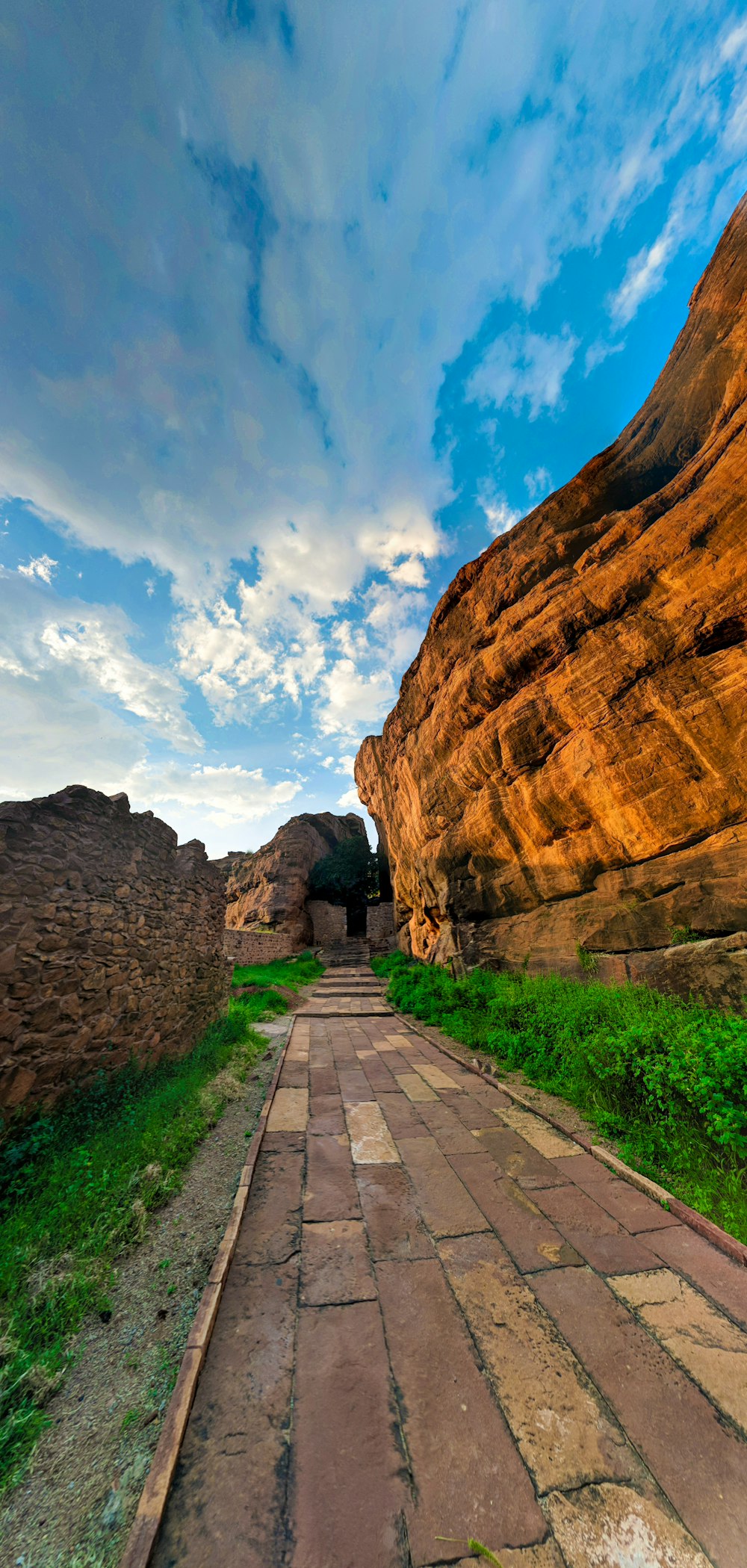 concrete pathway inline of stone cliff