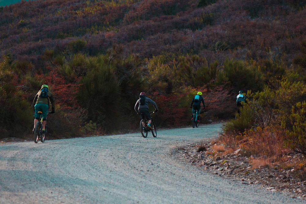 山のそばの砂利道を走るサイクリスト