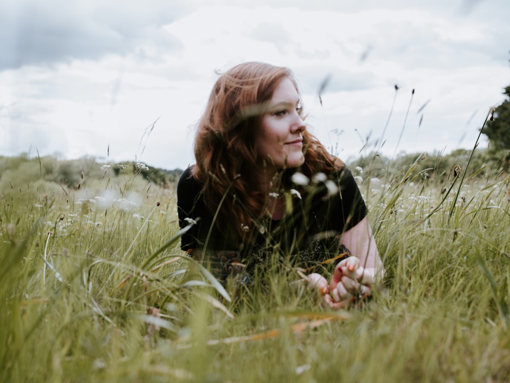 woman lying face down on grass field