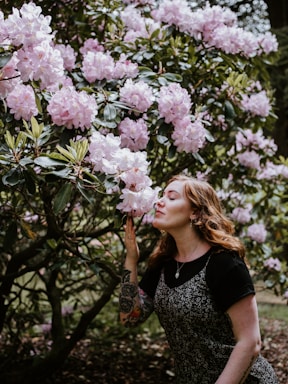 photography poses for women,how to photograph woman sniffing white and pink blooming flowers