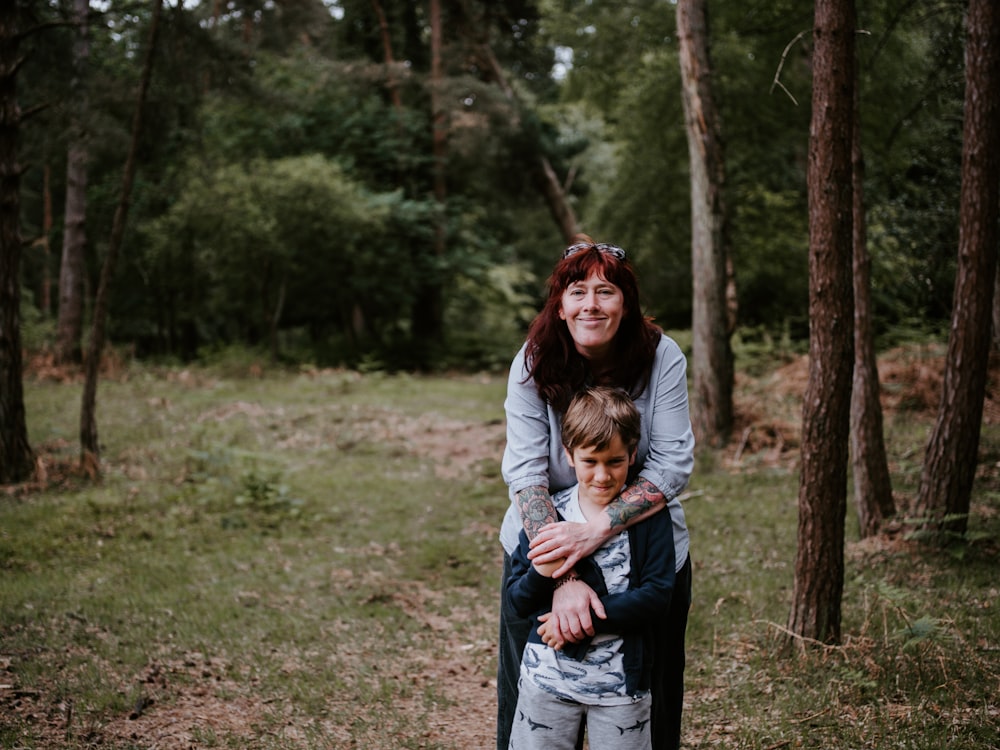 woman hugging boy during daytime