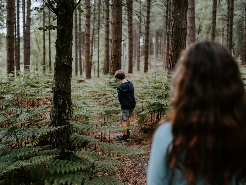 shallow focus photo of boy standing near plants