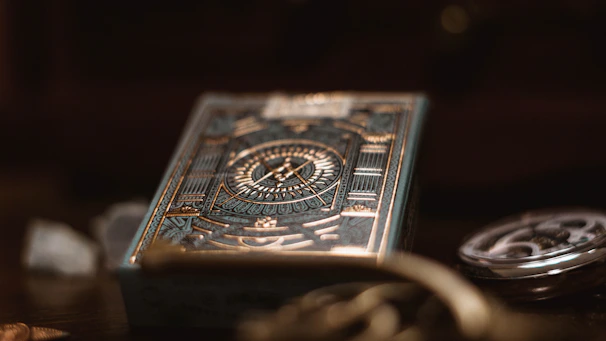 A close-up of elegant, dark playing cards with golden typography and subtle fire texture.