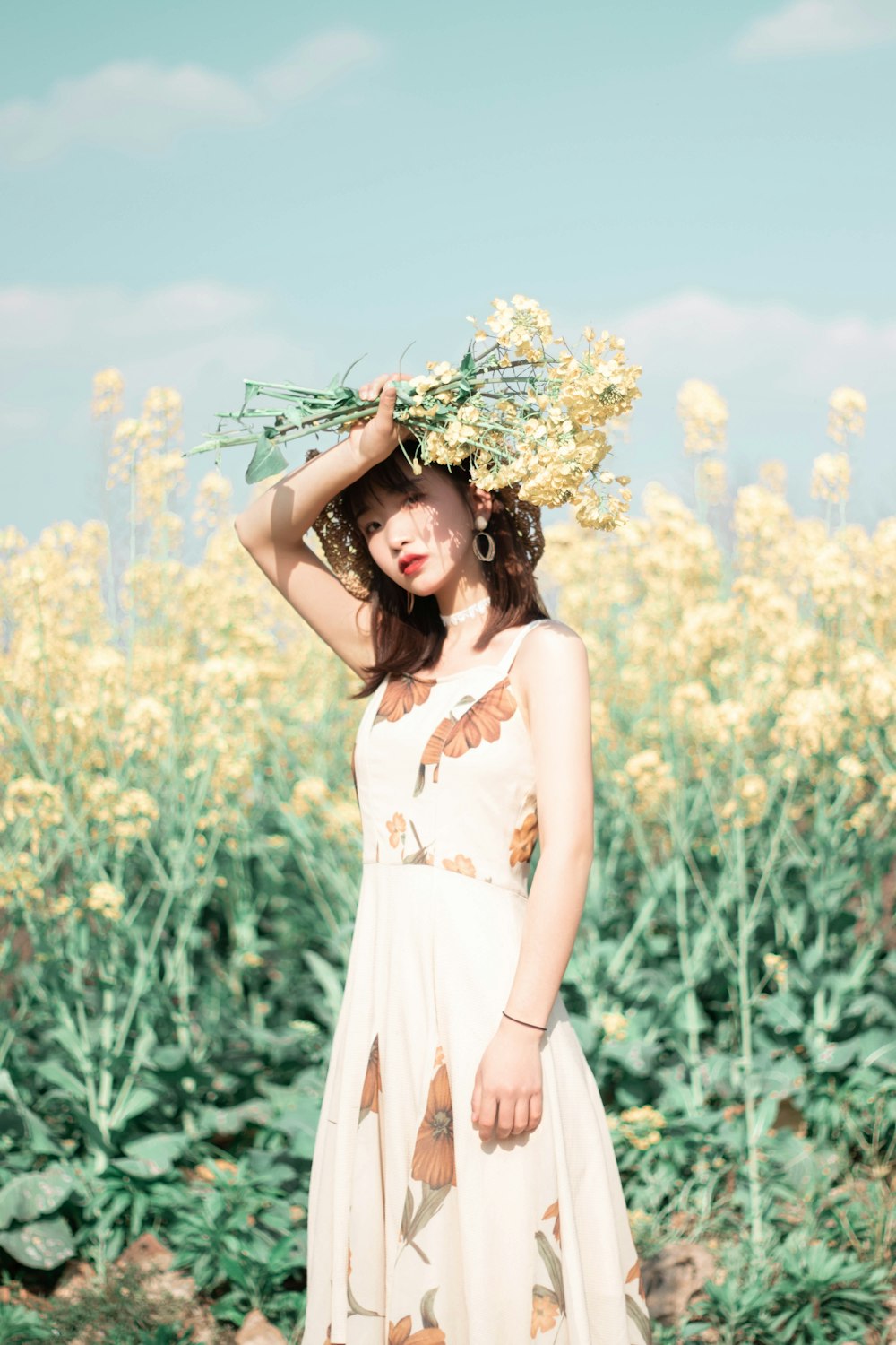 woman holding yellow-petaled flowers above her head