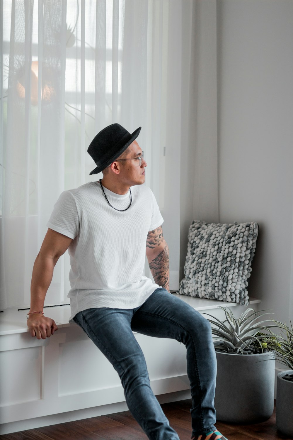 man in white crew-neck T-shirt wearing black fedora hat