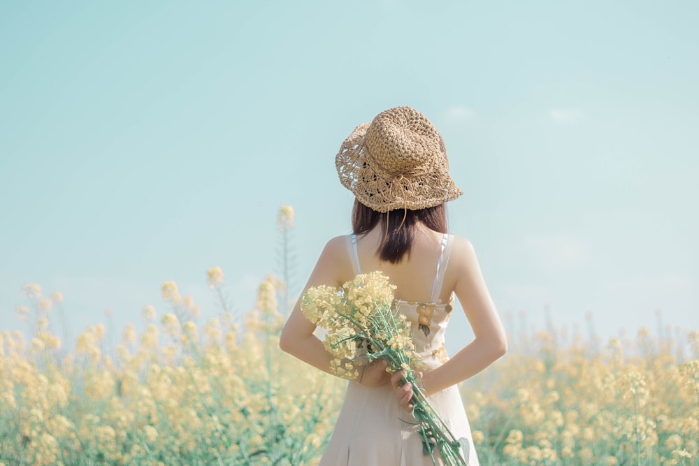 흰 드레스를 입은 여자가 꽃을 들고