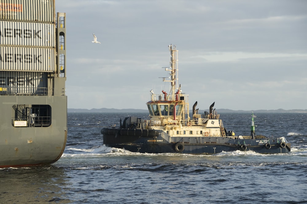 black and gray boat near ship during daytime